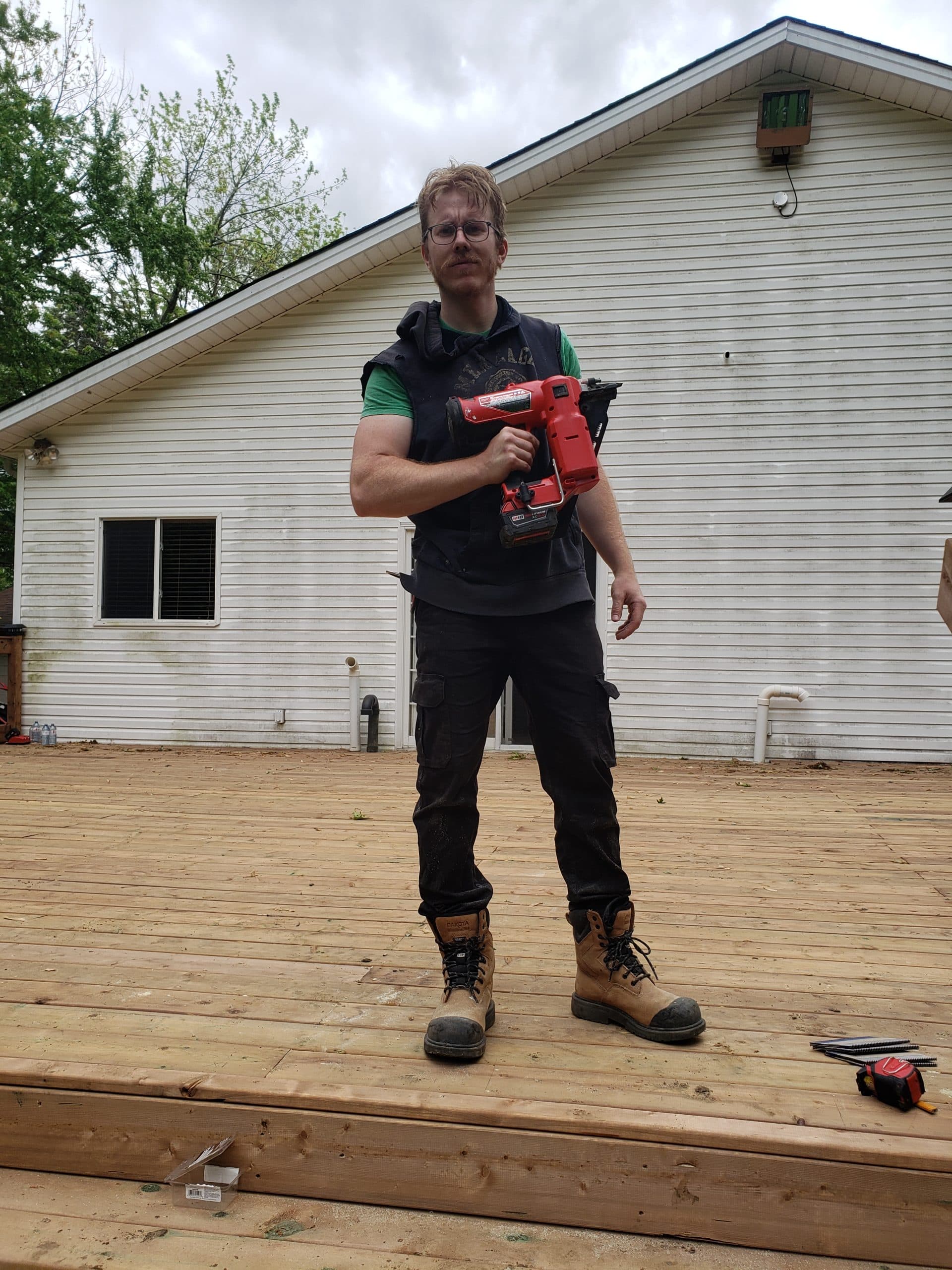 Sam Molloy, founder of Big Red Builds, standing on a freshly built deck
