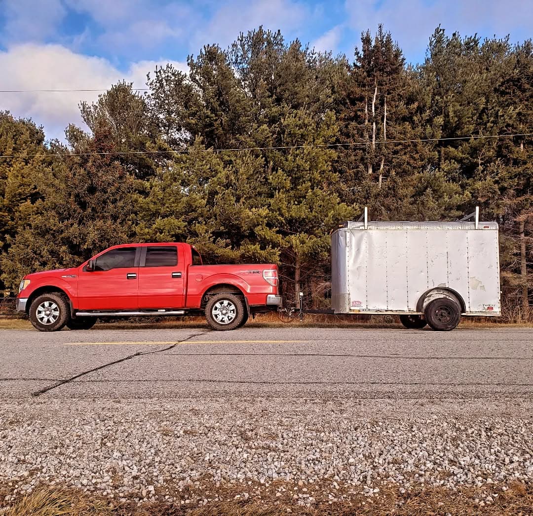 The red Big Red Builds truck and trailer heading to a jobsite