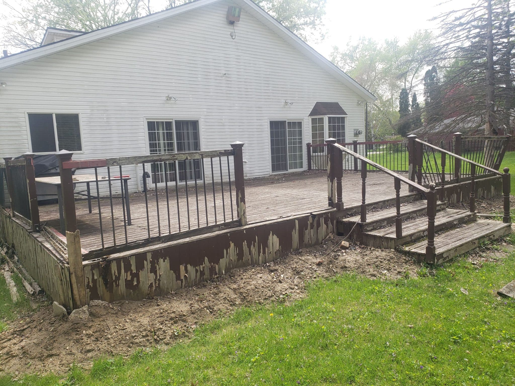 Aging deck with deteriorating boards and skirt before the rebuild