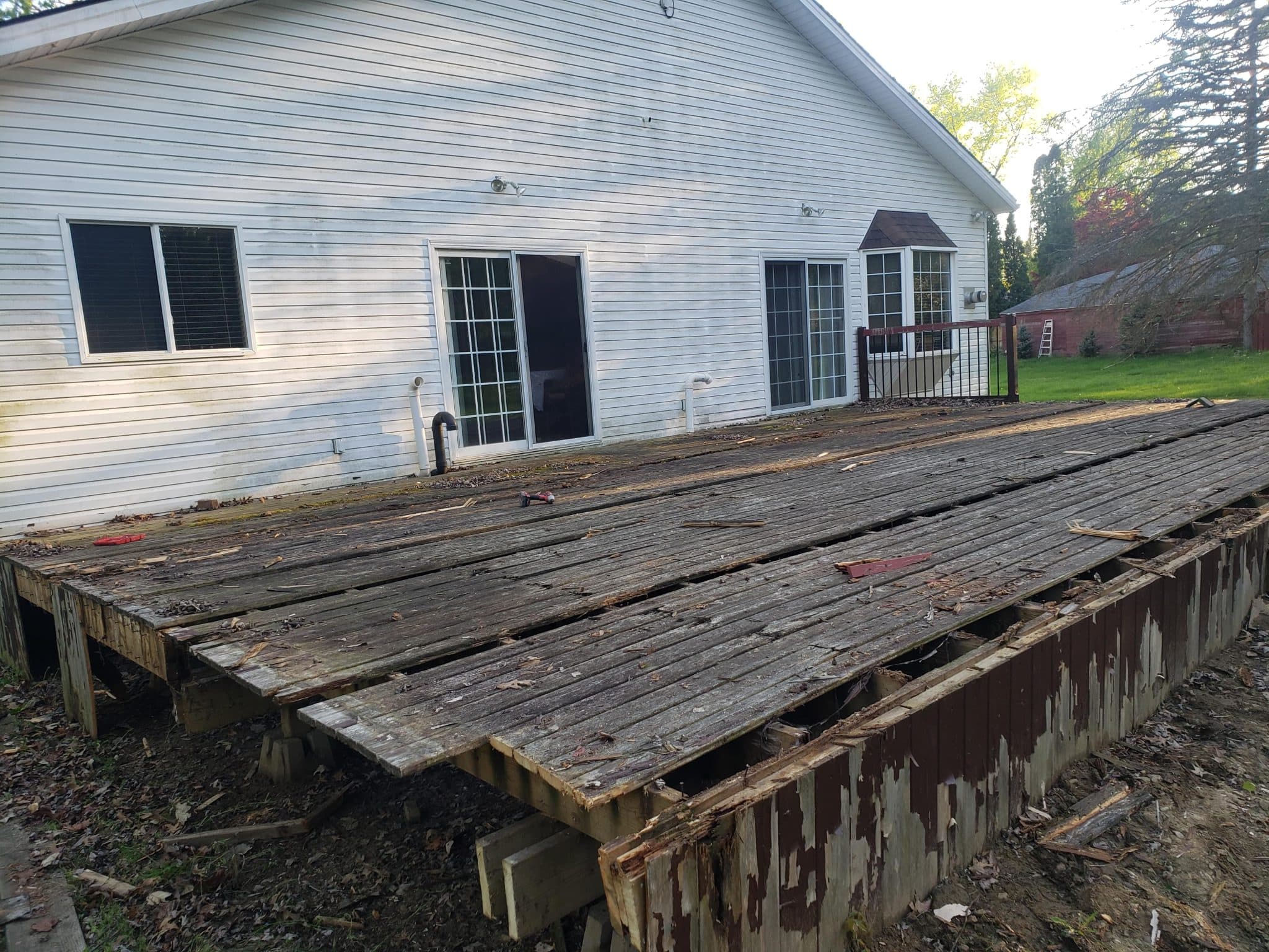 Old deck boards stripped down to the failing frame during demolition